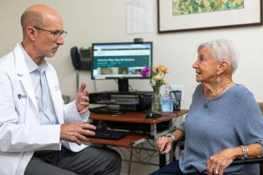 Male doctor sitting with an older woman discussing care