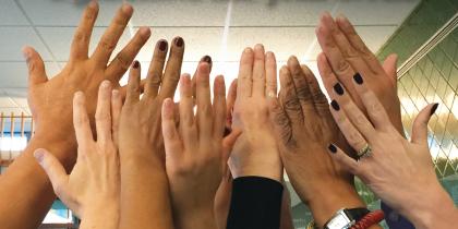 A group of people raise their hands in the air