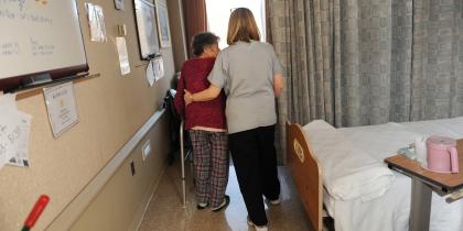 Medical assistant with a senior patient who is walking with a walker