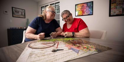 Two older women working on a puzzle