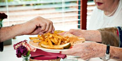Photo of older people sharing a plate of fries