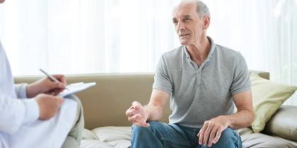 Older man sitting down with a doctor talking.