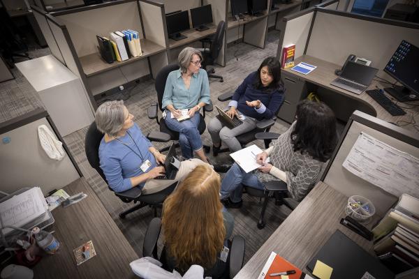 A group of female researchers have a discussion about a study.