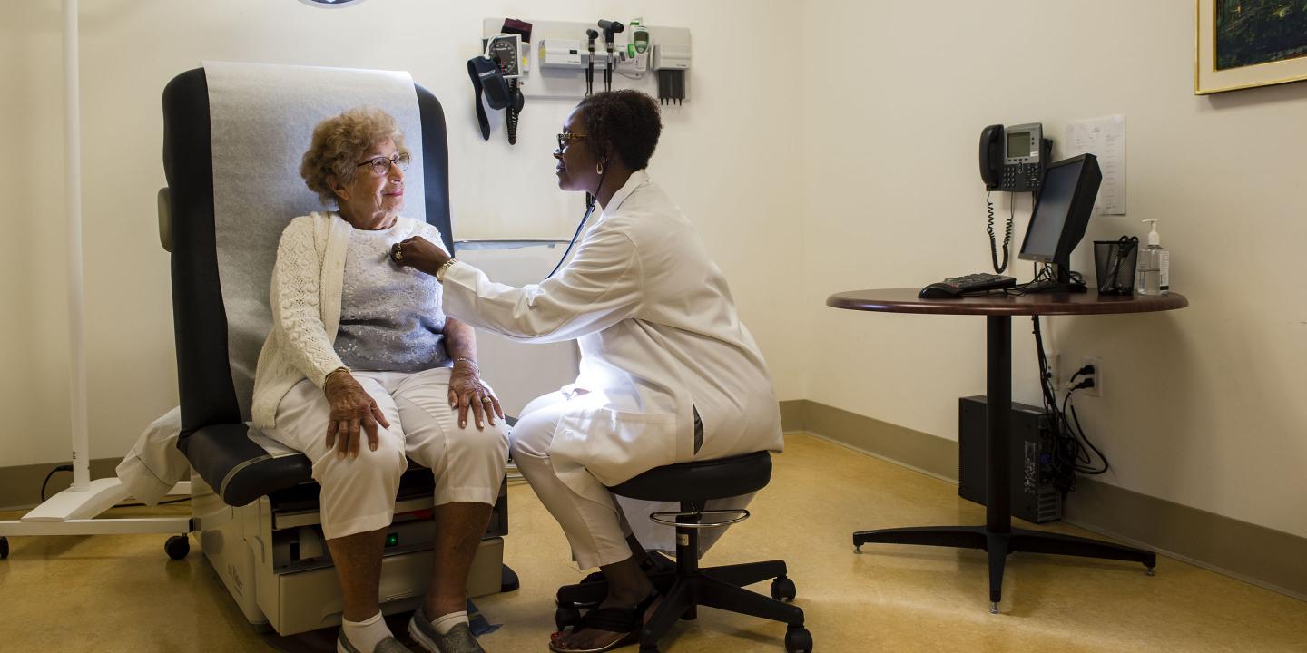 A NewBridge resident is seen by her Harvard Medical School-affiliated geriatrician at the on-site medical practice.