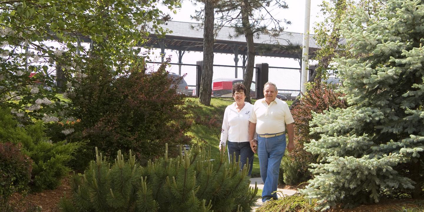 Man and woman walking, holding hands, outside Jack Satter House 