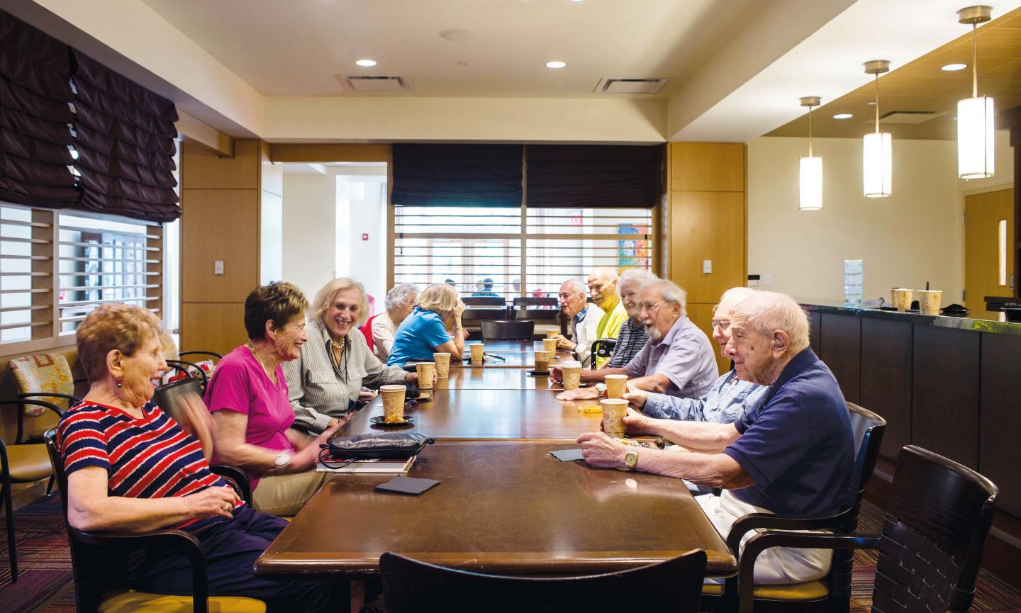 A group of NewBridge residents enjoy coffee and conversation following a theatrical performance in Great Meadow Hall.