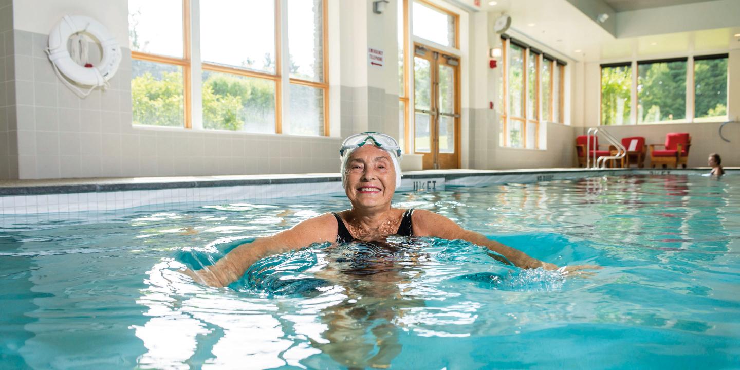 Smiling older woman in pool at Orchard Cove