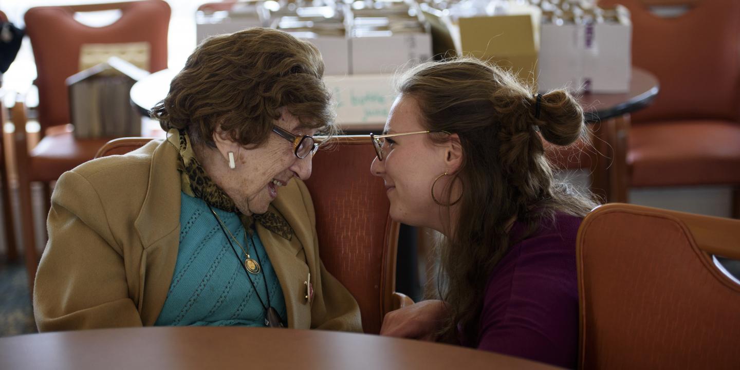 A Hebrew SeniorLife staff member chats with a Center Communities of Brookline resident.