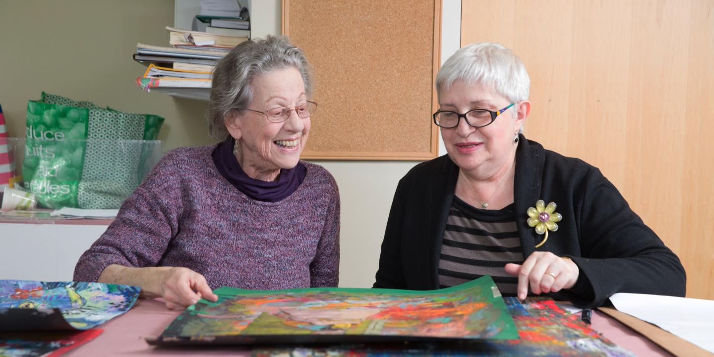 Two residents of Center Communities of Brookline look at their artwork together.