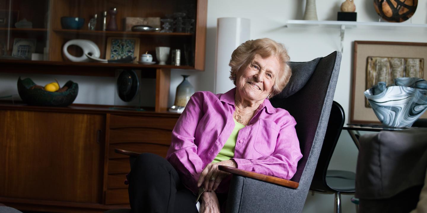An older woman sits in a comfortable enhanced living apartment at Orchard Cove