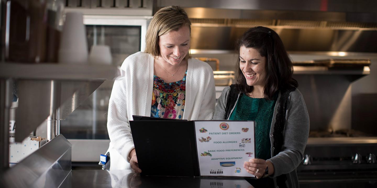 A dietetics intern and dietitian review a set of patient orders in a kitchen at Hebrew Rehabilitation Center in Boston.