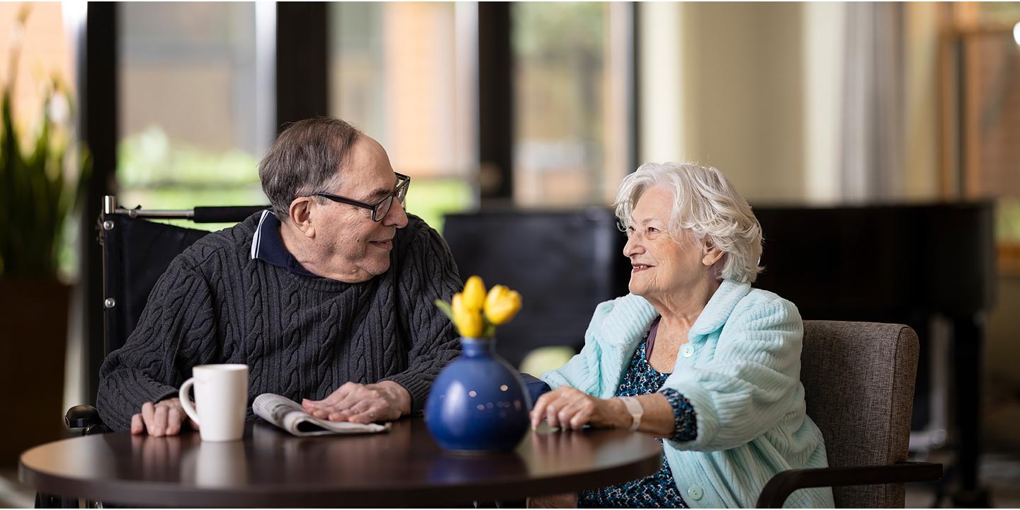 Older couple sitting together at a table in a lounge area