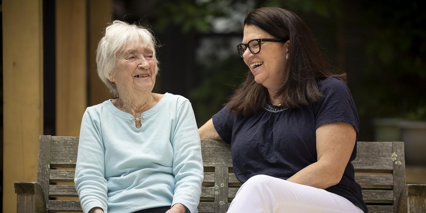 An older female resident and her daughter enjoy a laugh.