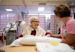 Seated senior receives outpatient therapy.