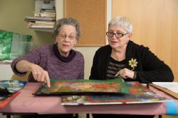 Two female residents peruse art work