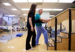 Patient practices climbing stairs as part our outpatient therapy at Hebrew Rehabilitation Center