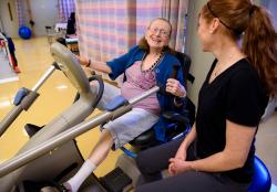 Senior uses exercise bike to gain strength.