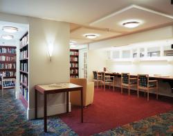 Book-filled shelves and plenty of work space line the CCB library.