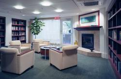 Bookshelves lined with books and sun-filled windows create a comfortable sitting area for CCB residents.
