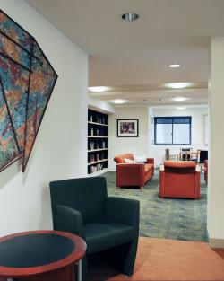 The entrance to a sitting area, with comfortable chairs and book-lined shelves.