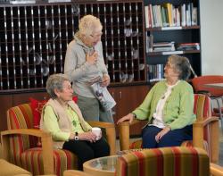 Three woman enjoy a conversation in one of the many sitting areas at Center Communities of Brookline.