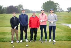 Four men stand on the golf green with Lou Woolf at a country club during the HSL’s golf fundraiser