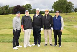 Five men stand on the golf green at a country club during the HSL’s golf fundraiser