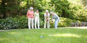 Four female residents play bocce ball outside 