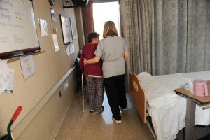 Medical assistant with a senior patient who is walking with a walker