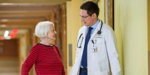 Doctor walking with older woman in a hallway