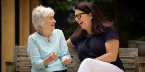 Middle-aged woman sitting with older woman