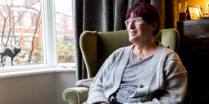Older woman sitting in a chair looking outside