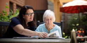Older woman sitting outside with another woman