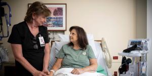 Woman nurse sitting with a woman patient 
