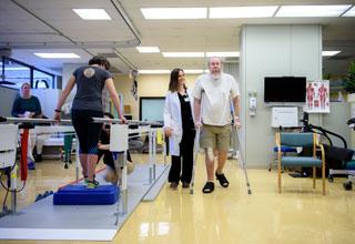 Older patients participate in rehabilitation therapy sessions, with therapists.