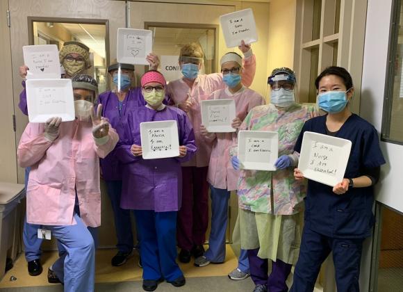 A group of nurses on HRC's COVID-19 Unit old signs saying "Nurses are Essential."