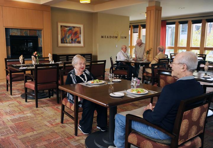 Several assisted living residents enjoy lunch in MeadowView, our restaurant offering three meals daily at NewBridge on the Charles.