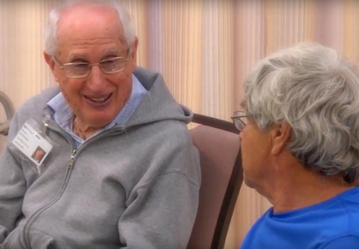 Two adult day health participants share a smile.