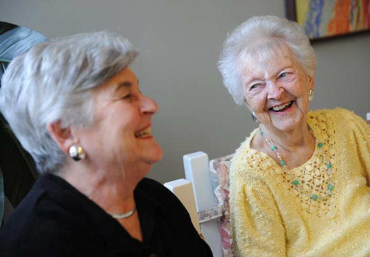 Adult daughter laughs with her mother, a long-term chronic care patient at Hebrew Rehabilitation Center