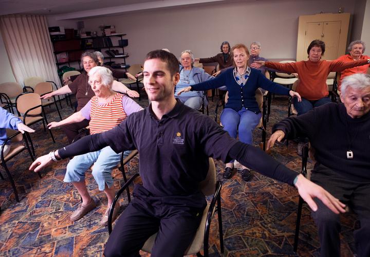 Fitness instructor with residents doing exercises