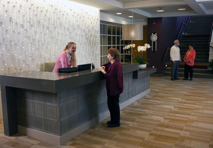 Front-desk receptionist helps a resident requesting a service.