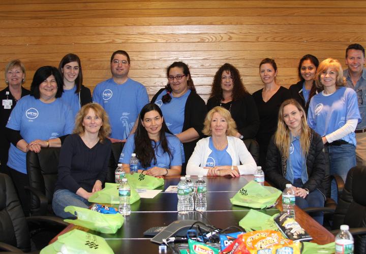 Corporate volunteers at Hebrew SeniorLife all together around a table after their day of volunteering