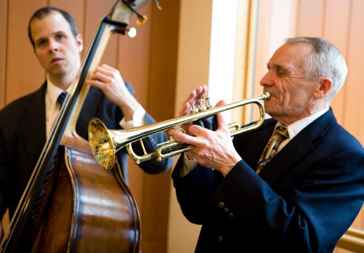 A man playing an upright acoustic bass and a man playing trumpet perform.