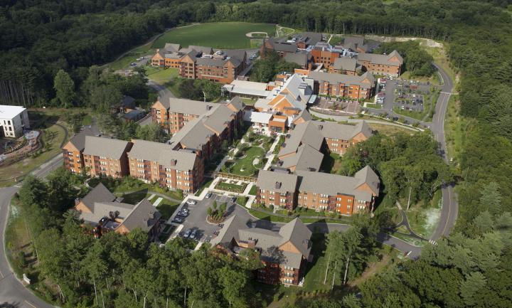An aerial view shows the NewBridge on the Charles campus, including independent and assisted living residences, surrounded by beautiful green space. 