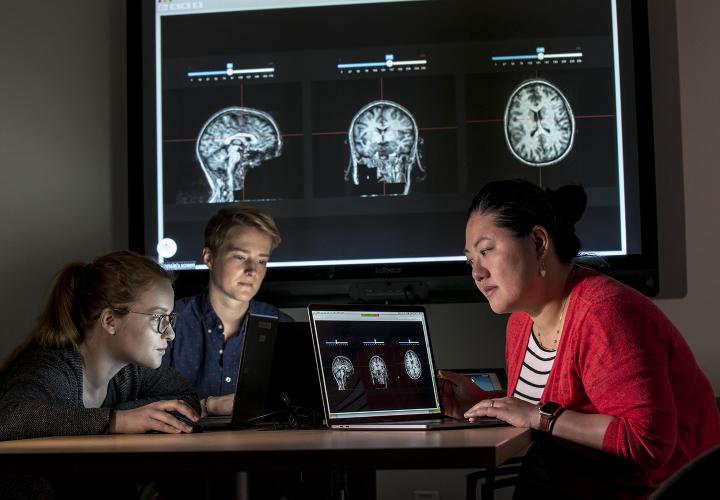 Three researchers from the Marcus Institute in front of scientific screen