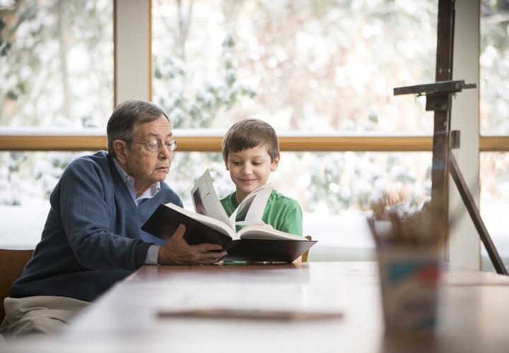 Man reading to boy in library at NewBridge on the Charles