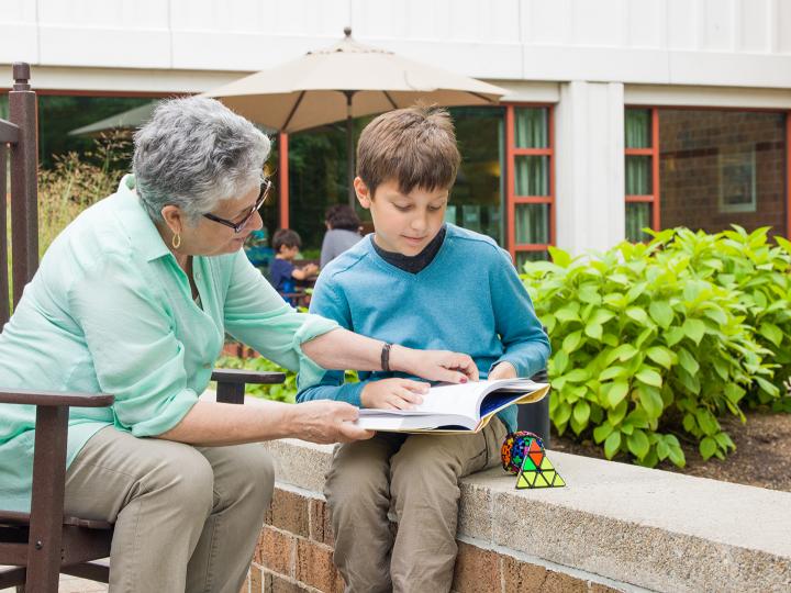 An Orchard Cove resident helps a local student during a tutoring session.