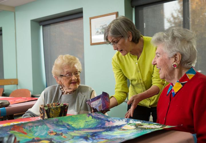 Residents looking at painting with staff member