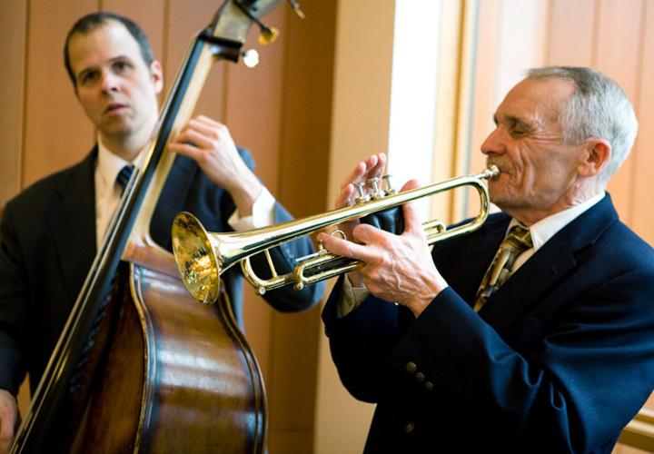 A man playing an upright acoustic bass and a man playing trumpet perform.