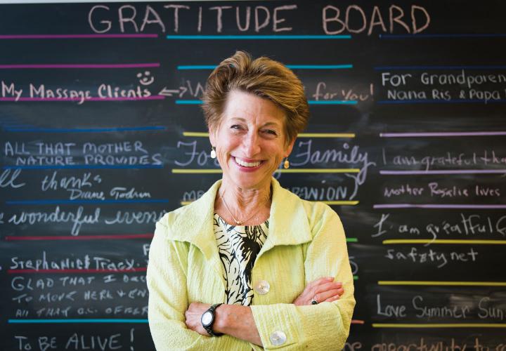 Vitalize 360 Coach stands in front of gratitude board created by residents.